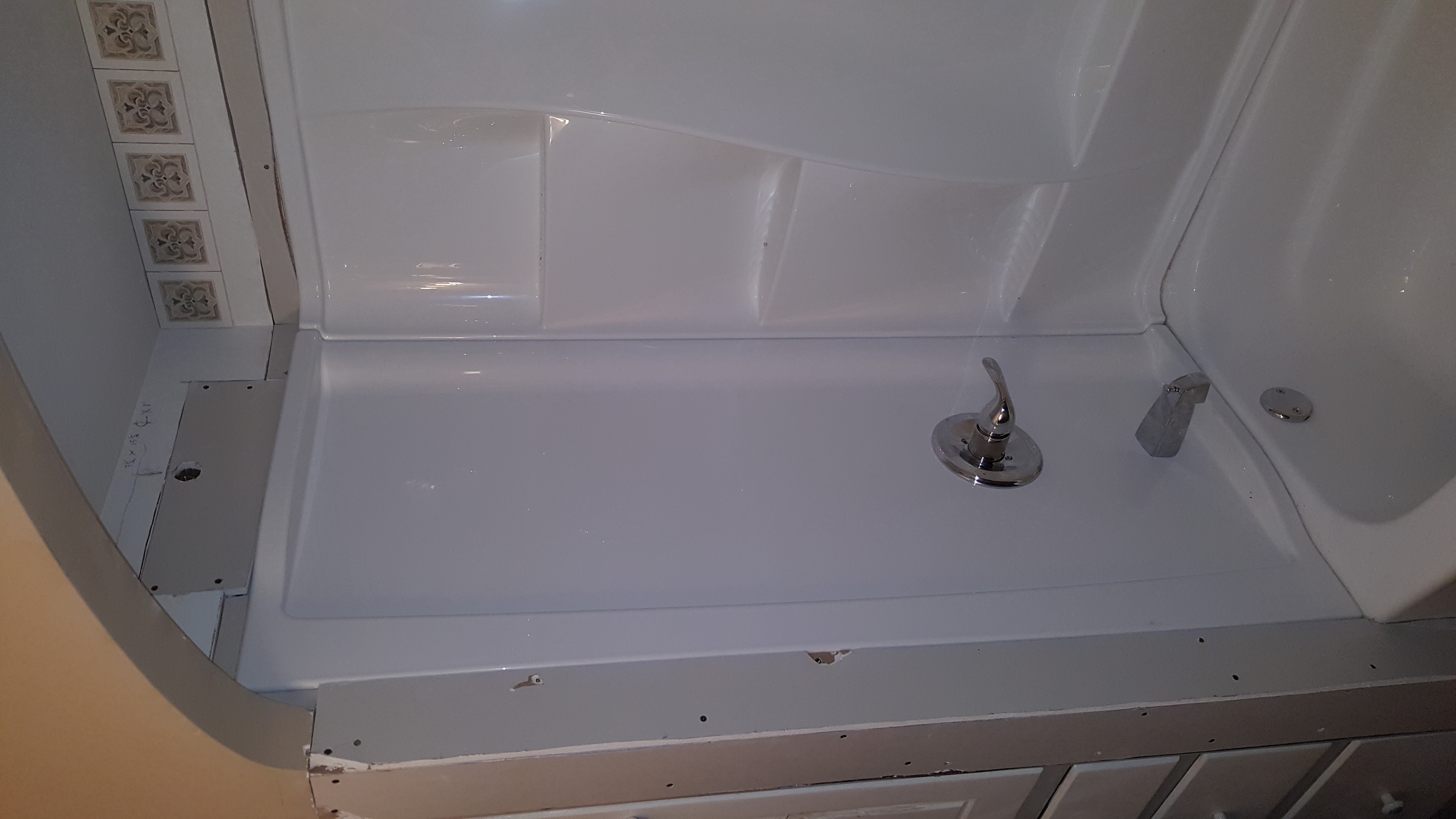 White vanity with granite countertop, two sinks, and window above