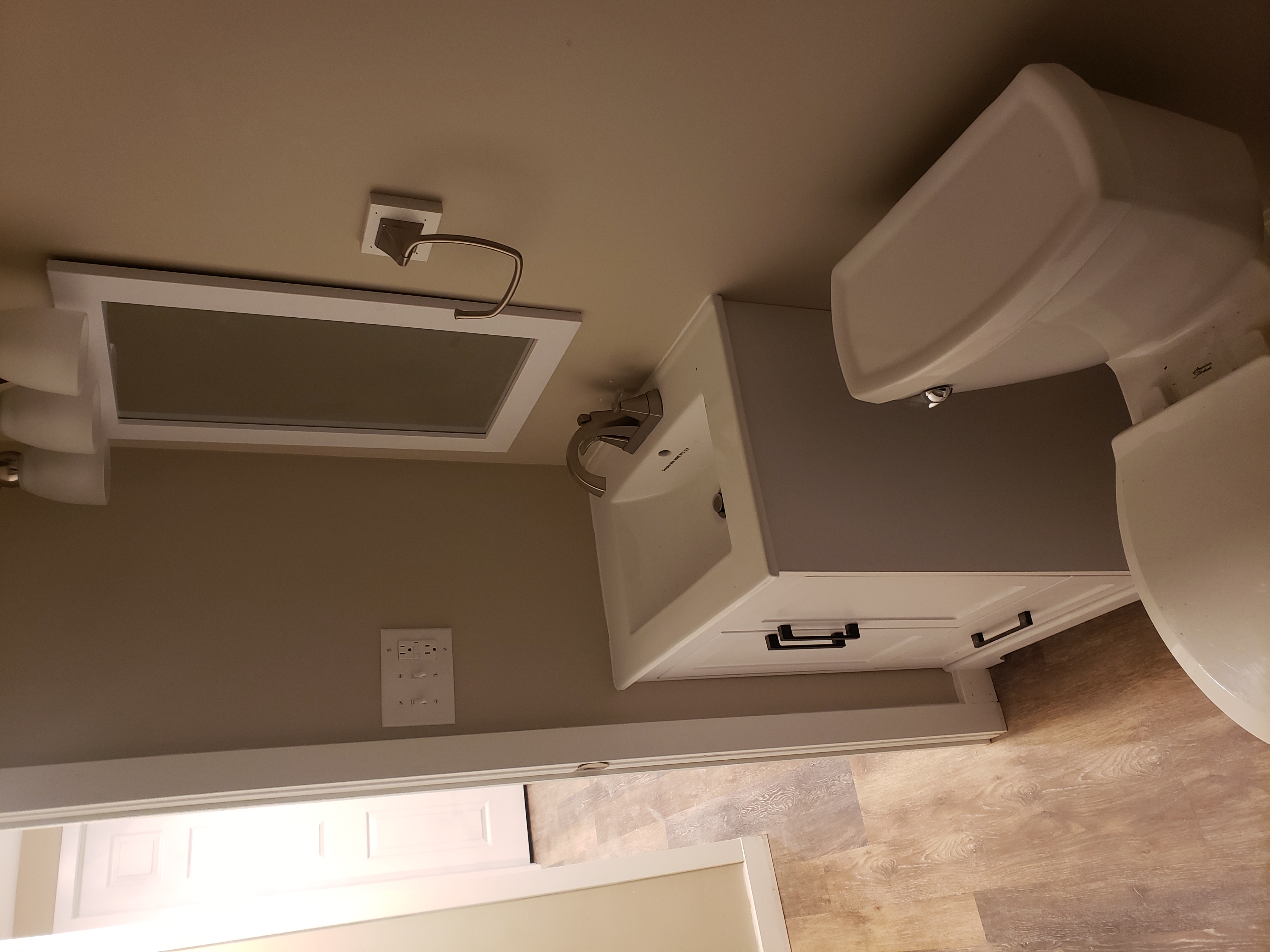 White shower stall installed in a wood-framed bathroom under construction; pink insulation visible