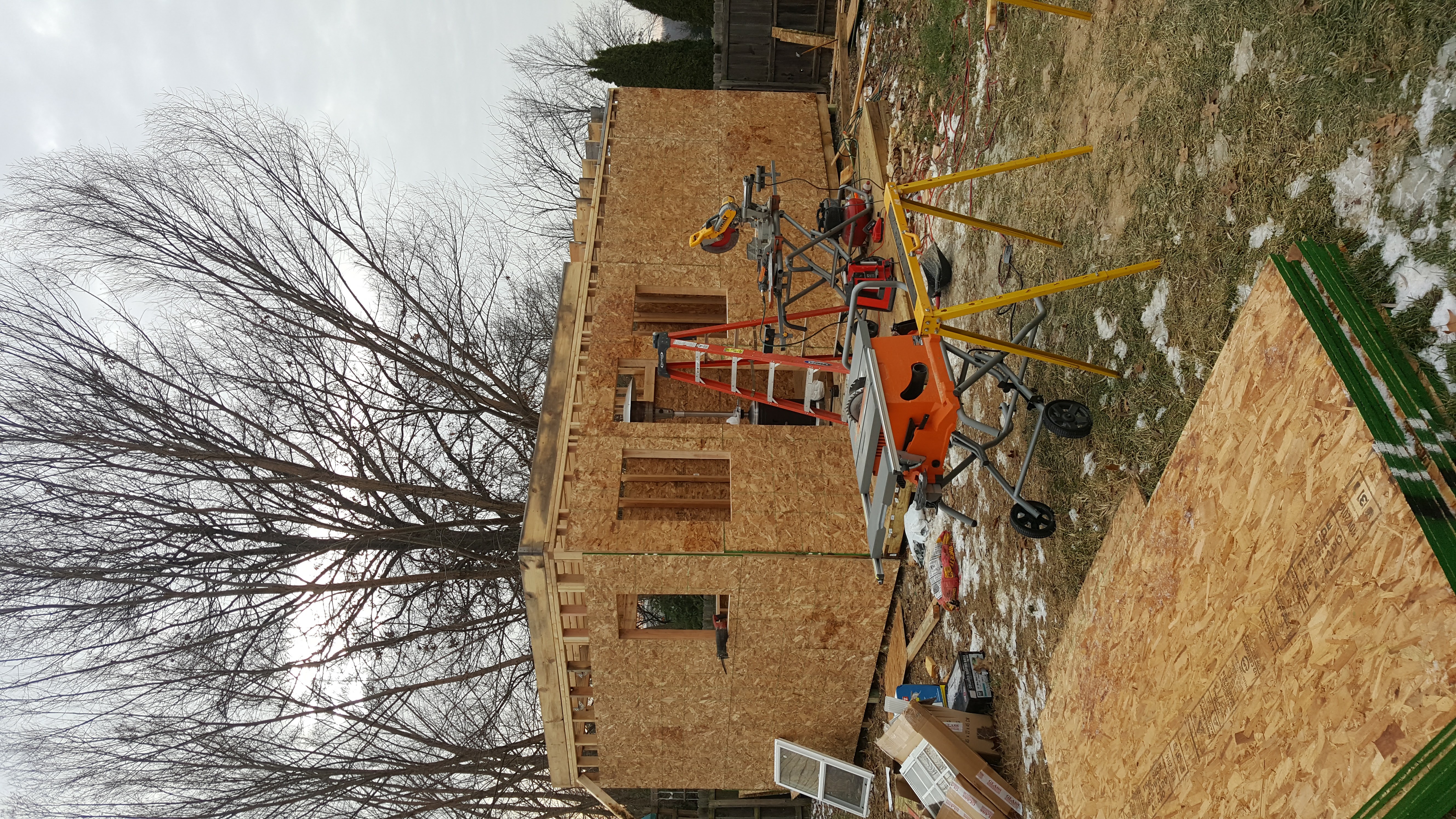 Staircase under construction with a window at the top; wooden structure visible, with beams and studs