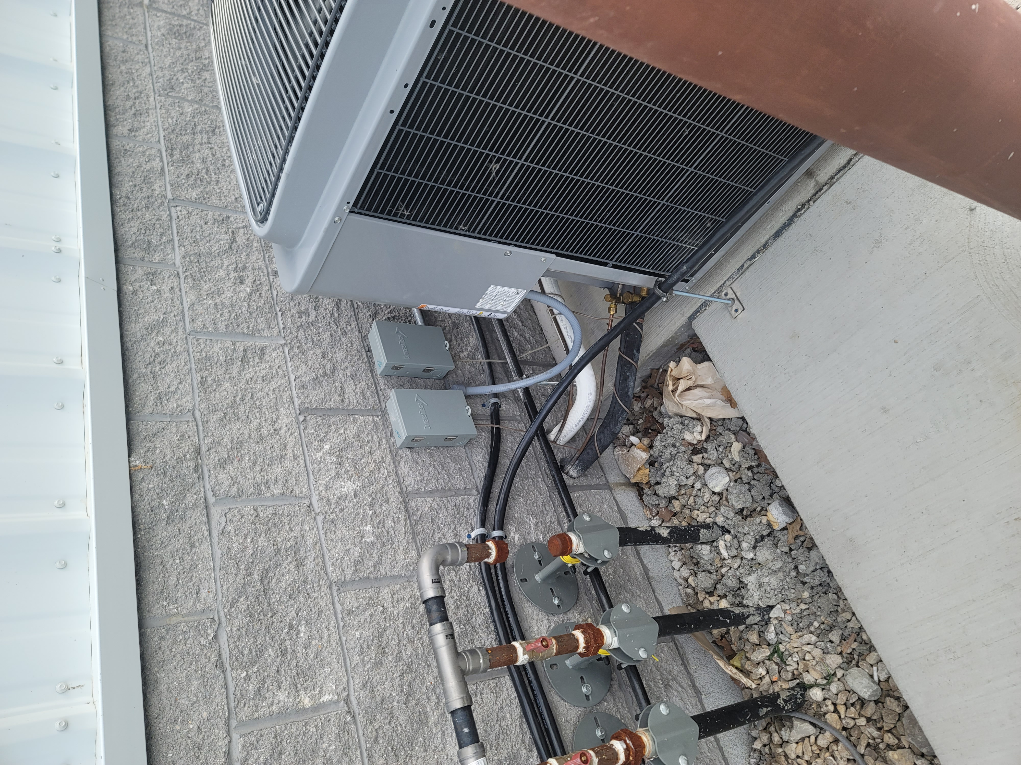Furnace with open panels in a basement; metal ductwork attached