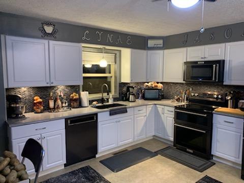 Gray kitchen with granite countertops and light-colored cabinets