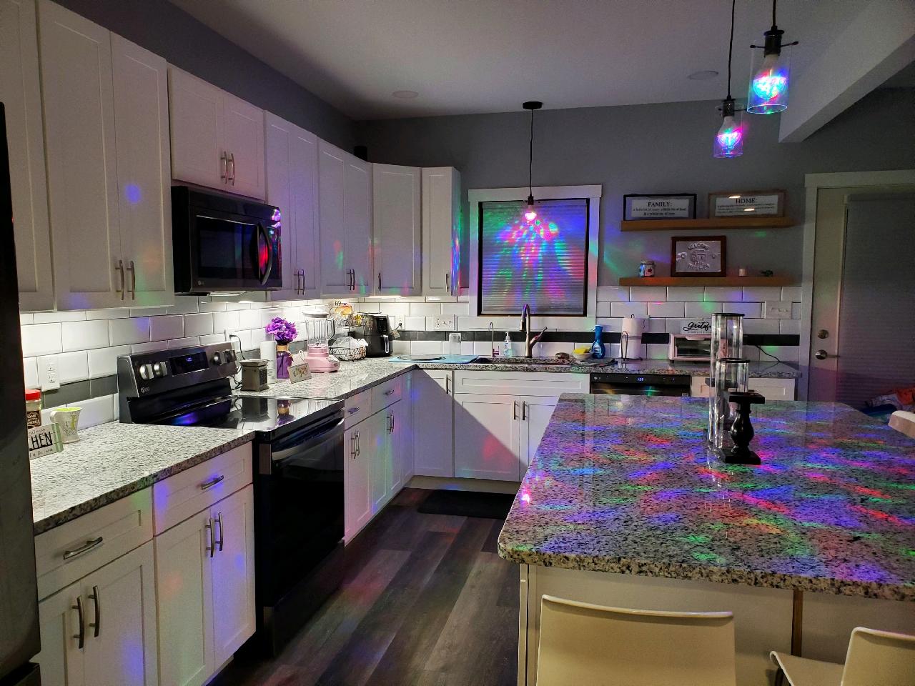 Modern kitchen with light gray cabinets, stainless steel appliances, and granite countertops