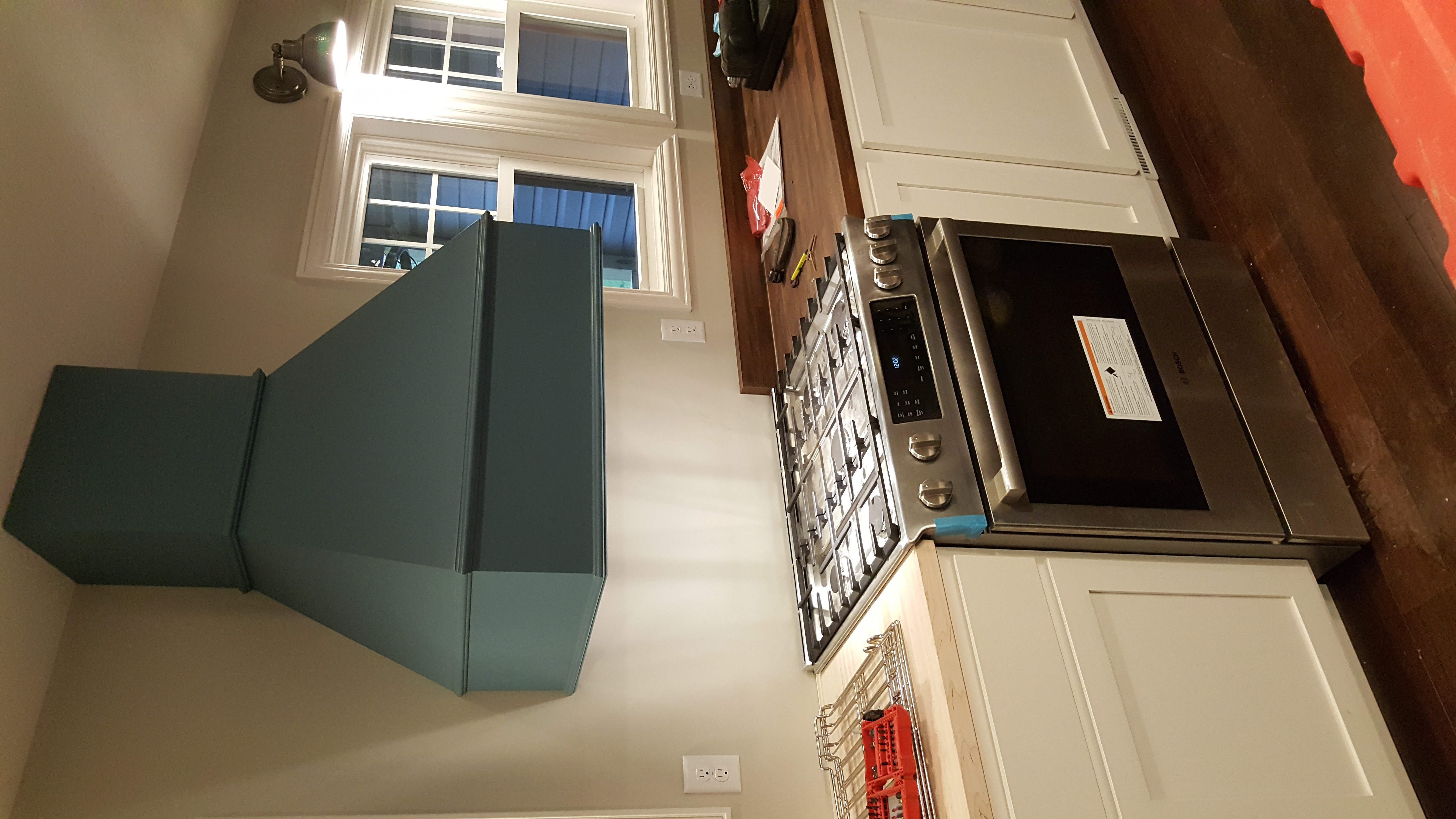 Backsplash tile installation in progress above a granite countertop, with tile spacers visible